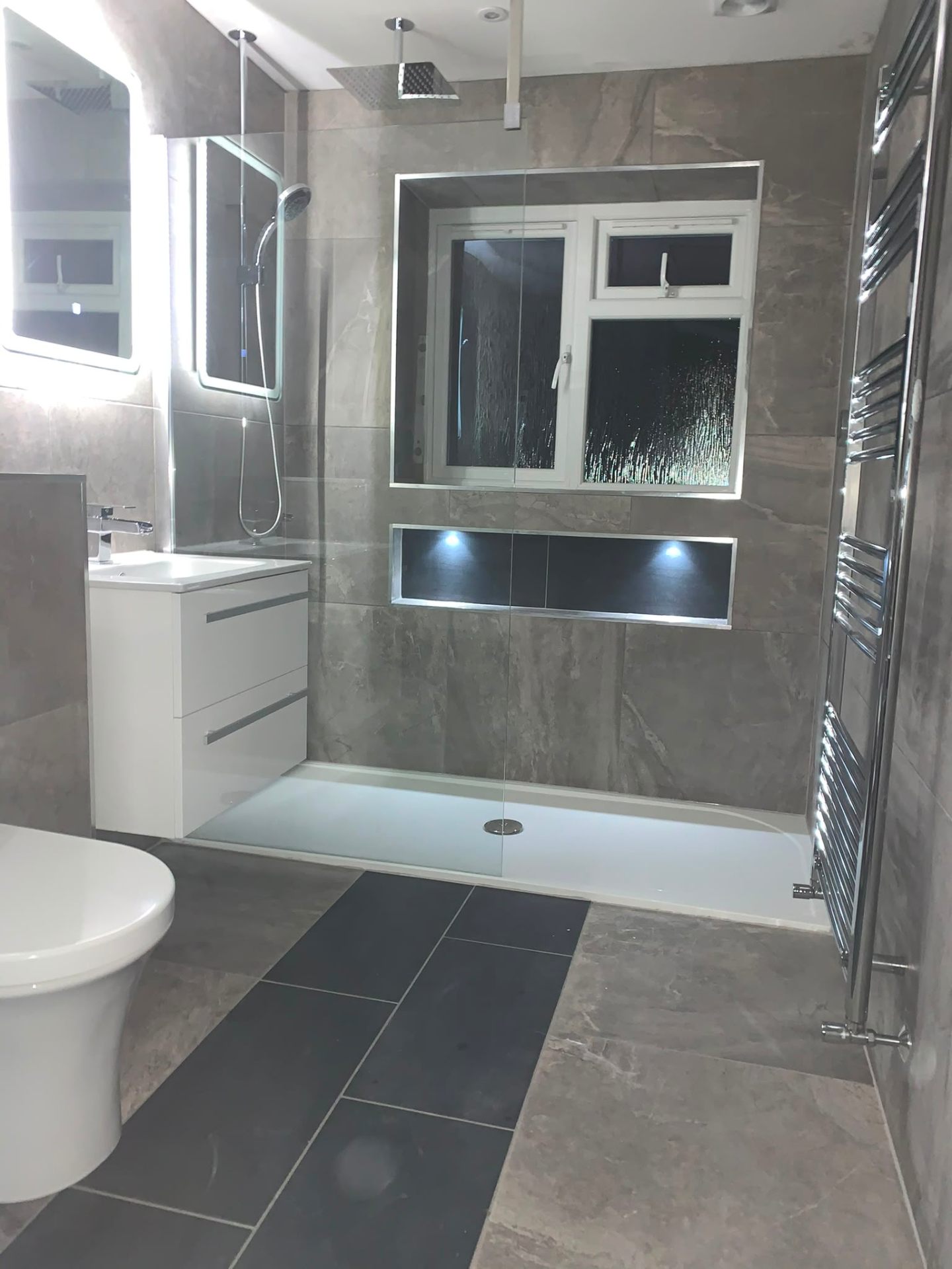 Grey stone-effect bathroom installation with walk-in shower and heated towel rail, Ashford