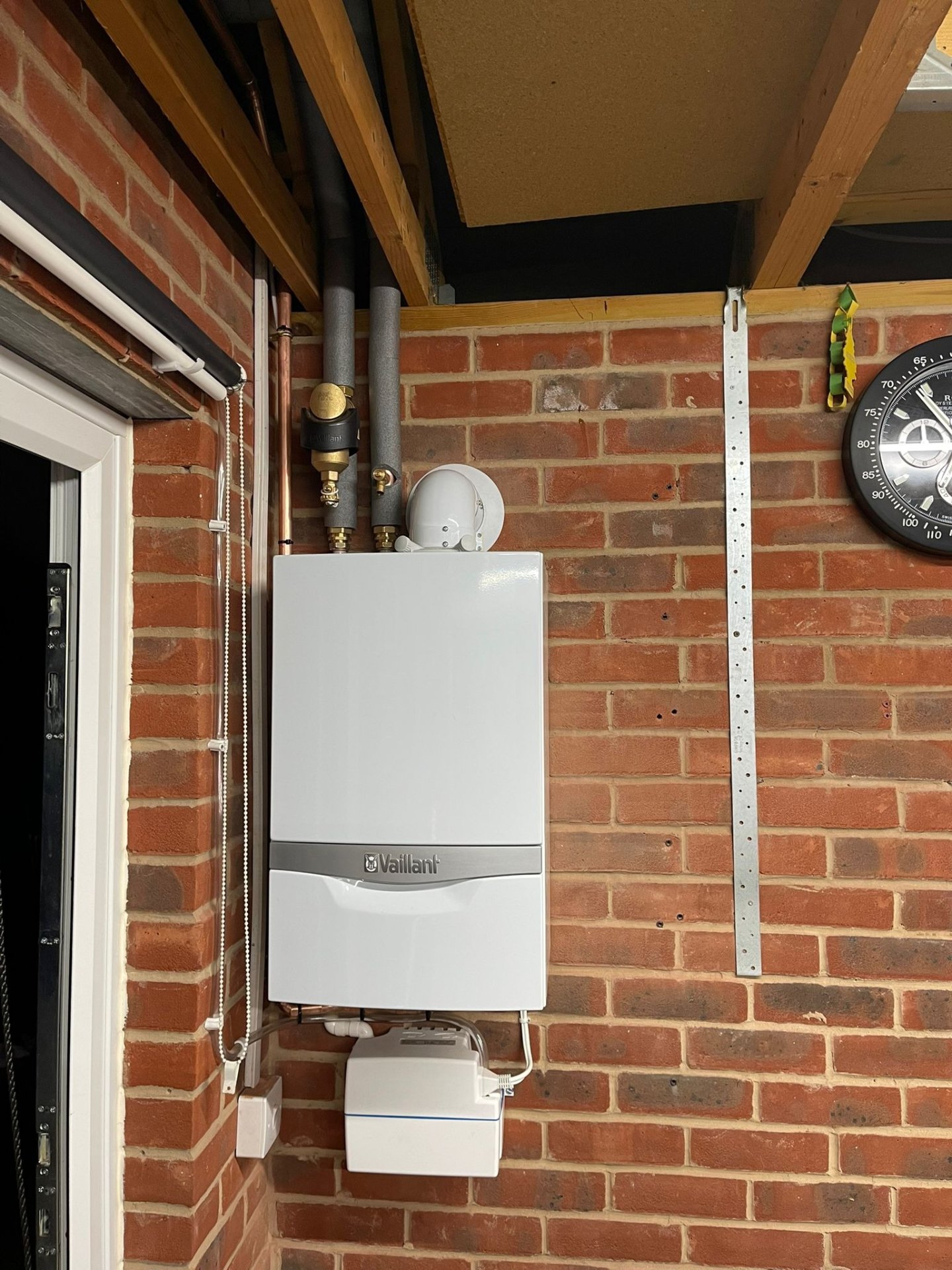 Wall-hung Vaillant boiler installed on exposed brick by Gas Safe engineer in Ashford, Surrey